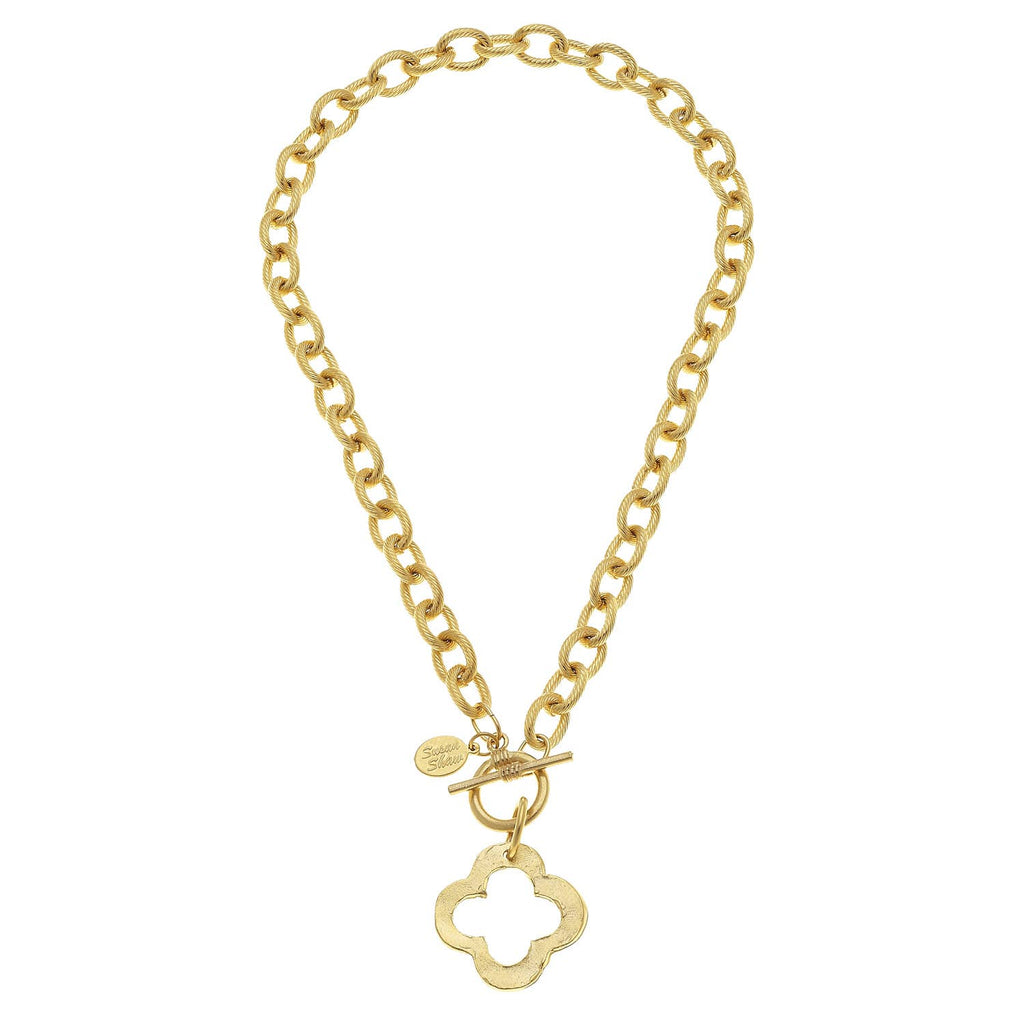 Gold chain necklace with a clover-shaped pendant on a white background