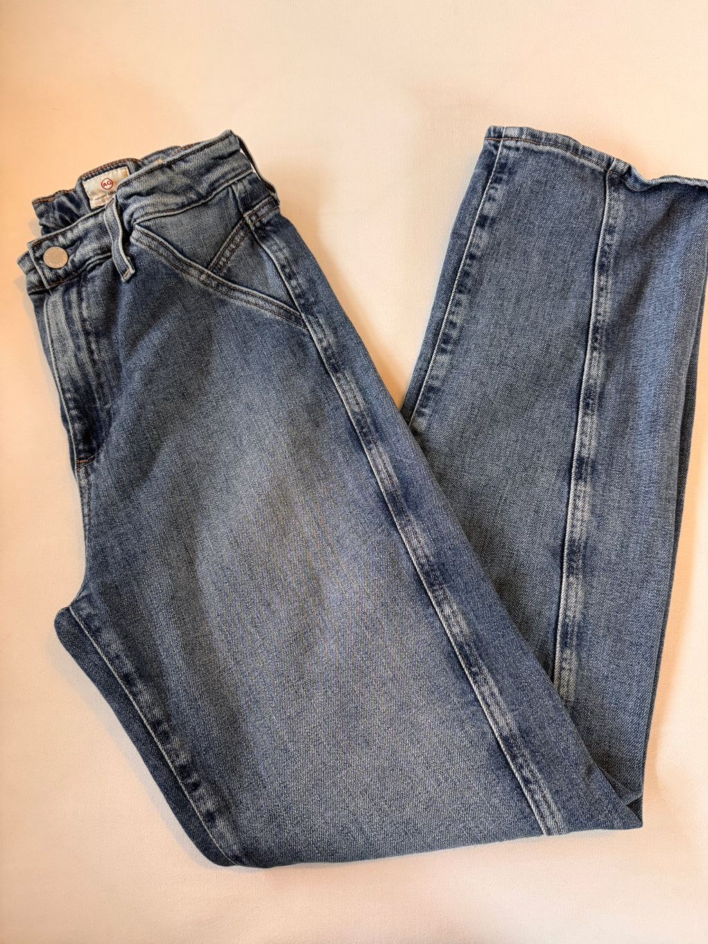 Pair of blue jeans on a beige background