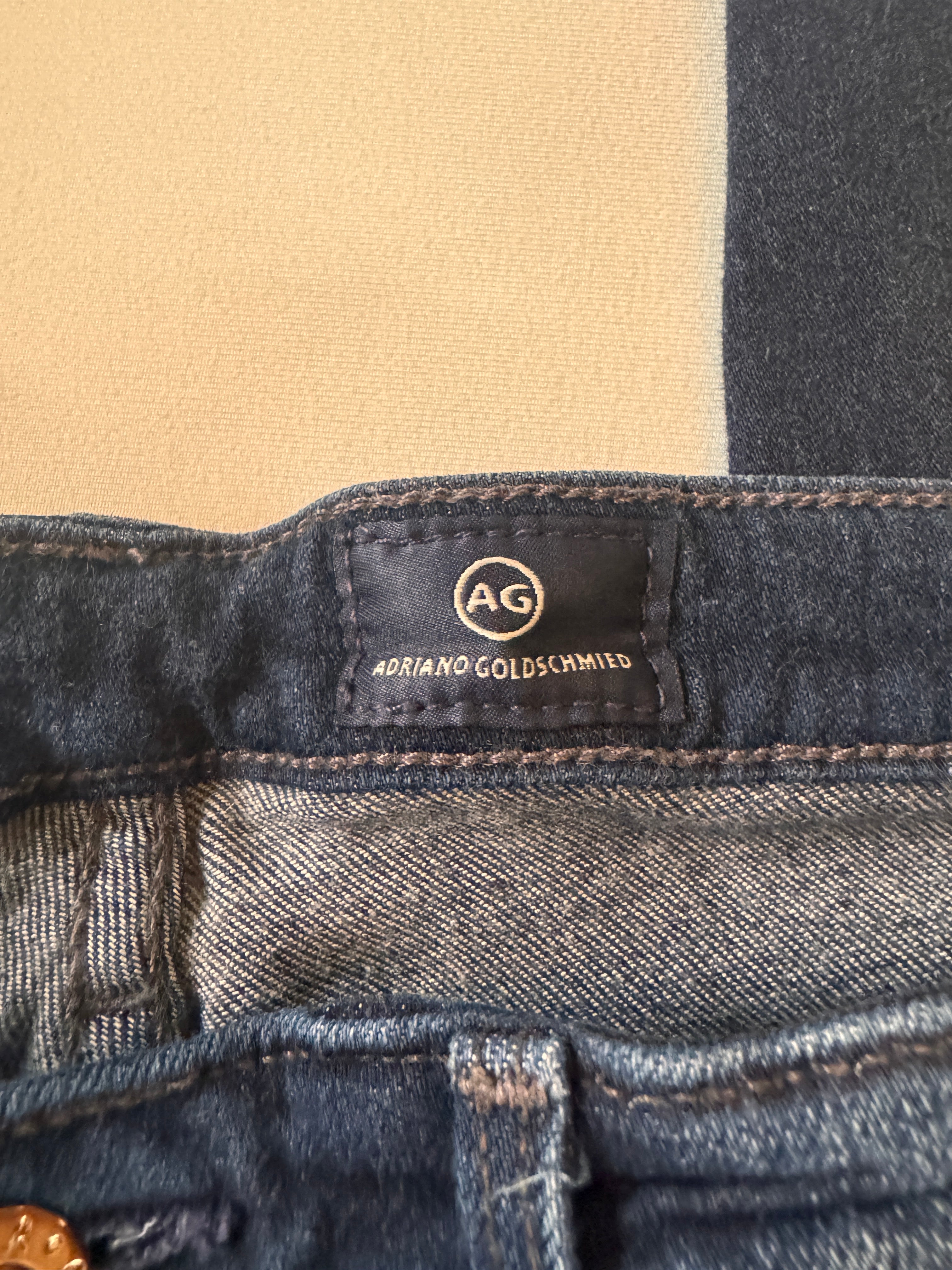 Close-up of a denim jacket with a brand label on a beige background