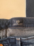 Close-up of a denim jacket with a brand label on a beige background
