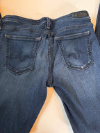 Close-up of blue jeans with a focus on the waistband and pockets.