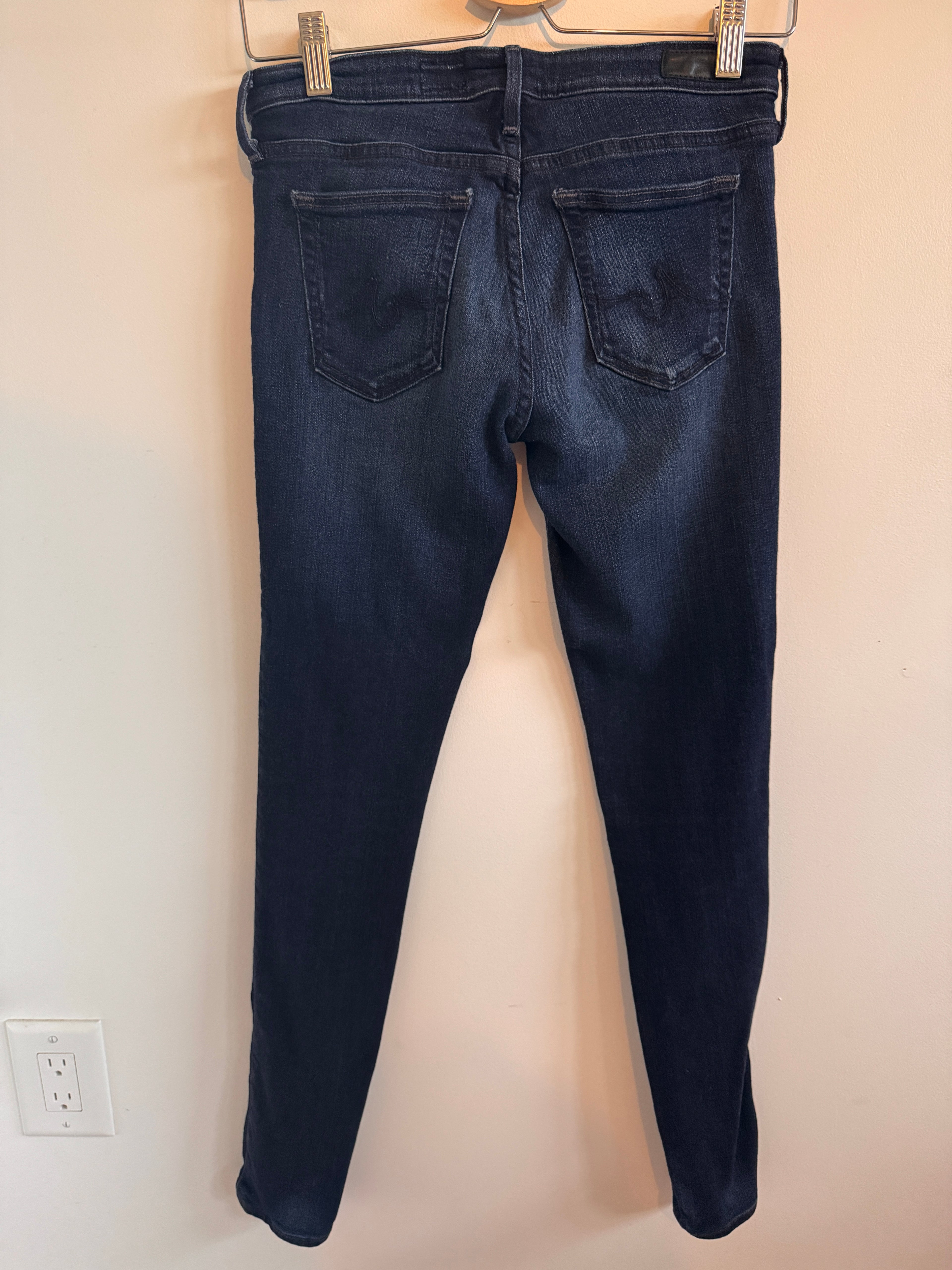 Pair of dark blue jeans on a beige surface