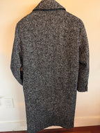 Gray herringbone patterned shirt on a white surface with a neutral background