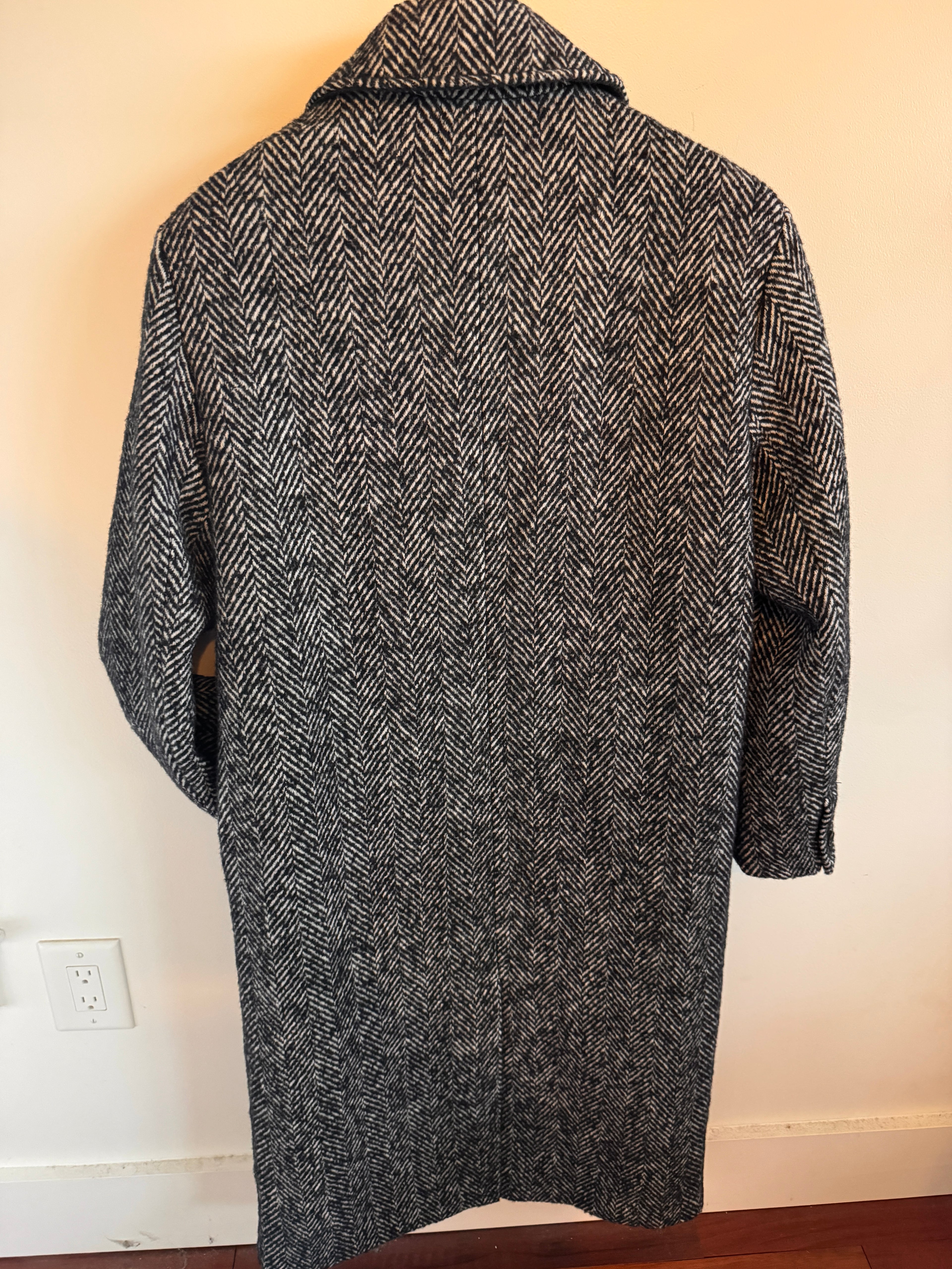 Gray herringbone patterned shirt on a white surface with a neutral background