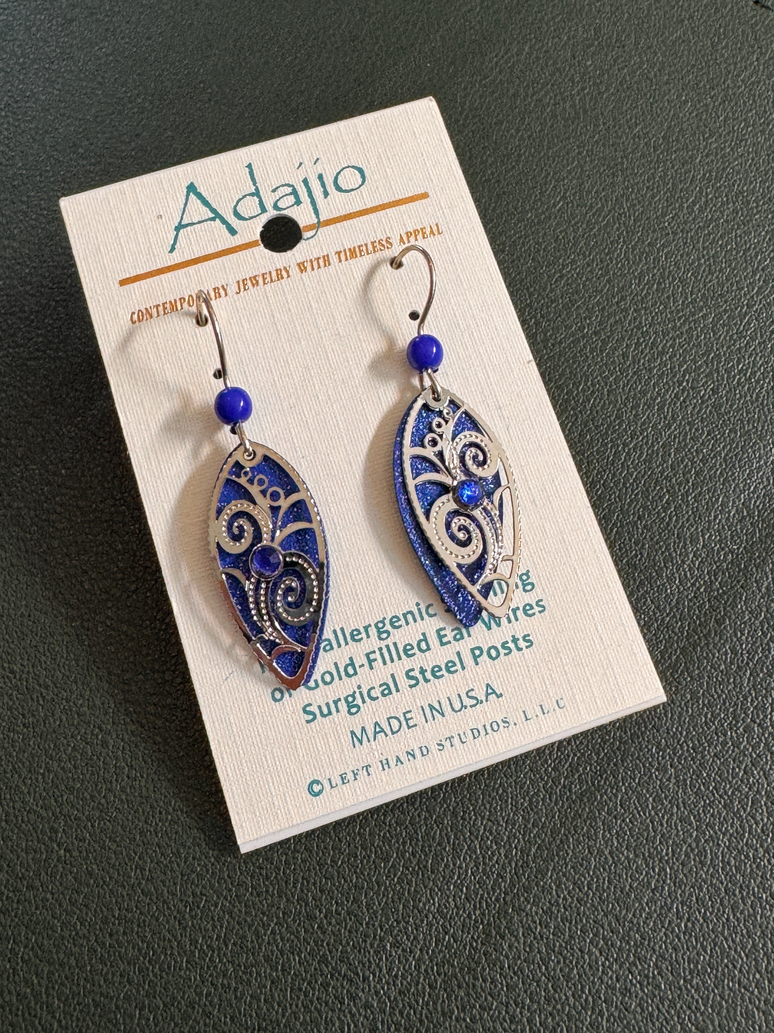 Silver and blue earrings with a bead and rhinestone on a card labeled Adajio