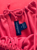 Pink sweatshirt with a blue label on a pink background