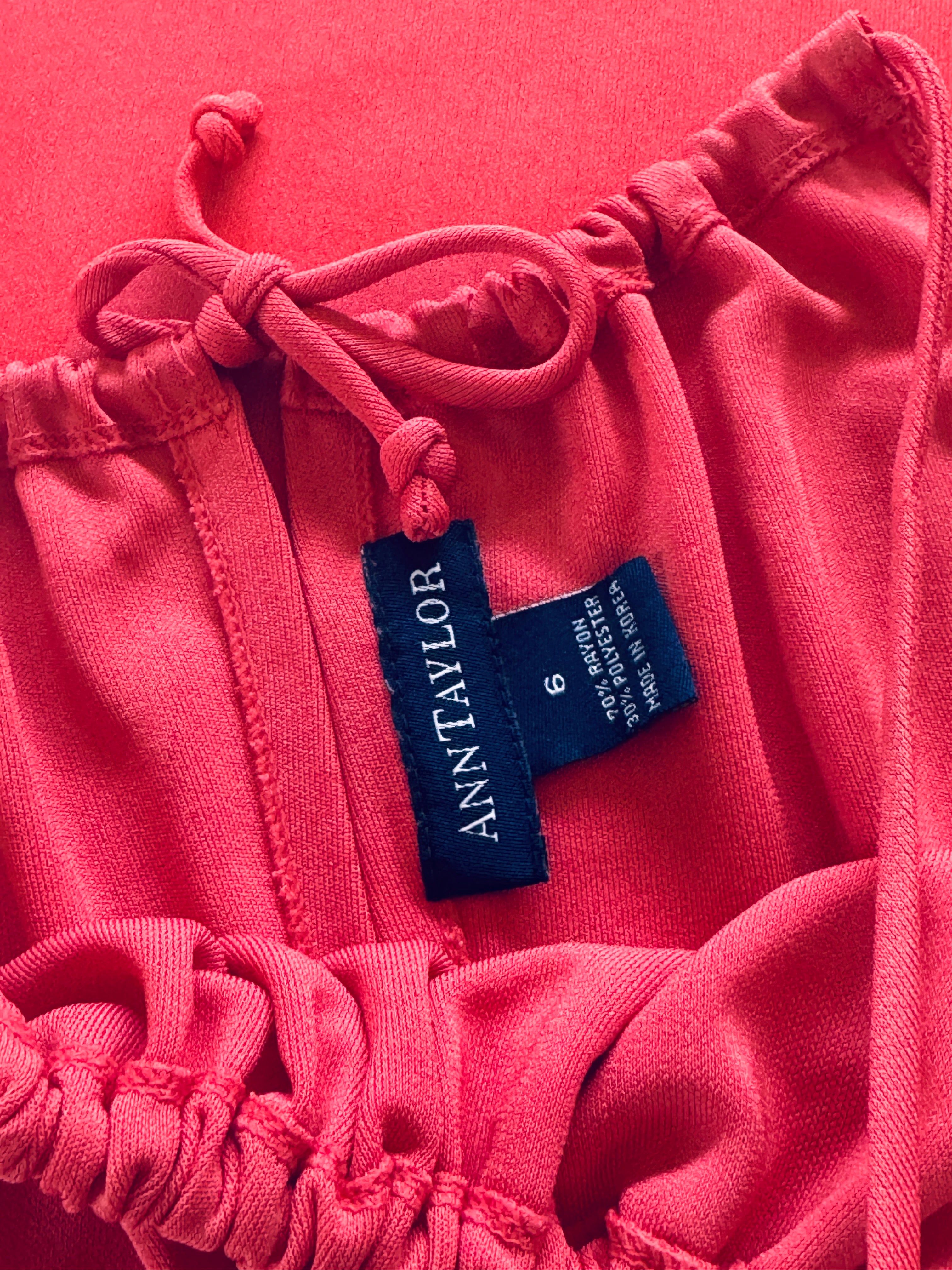 Pink sweatshirt with a blue label on a pink background
