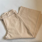 Beige pants folded on a light gray surface