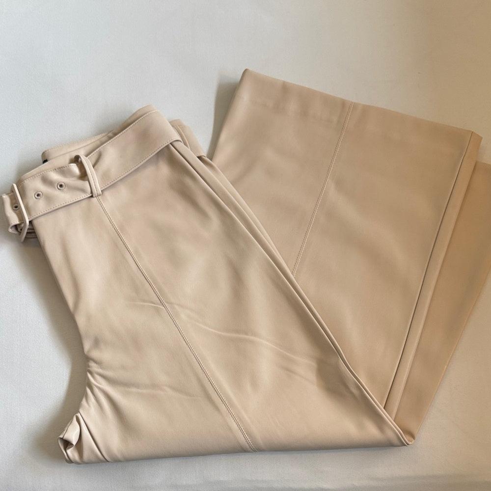 Beige pants folded on a light gray surface