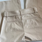 Beige leather pants with a belt on a light background
