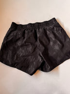 Black shorts on a beige background