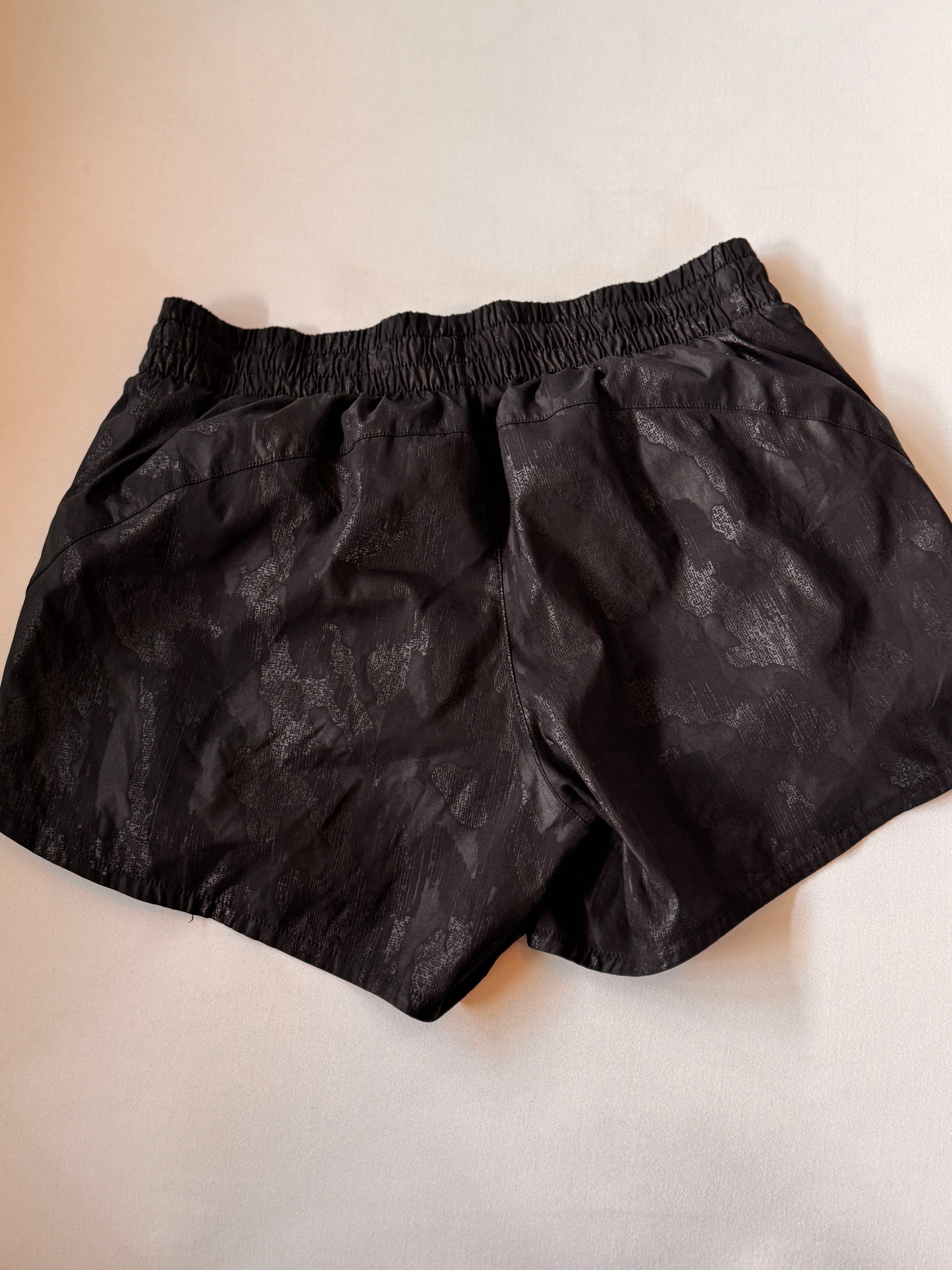 Black shorts on a beige background