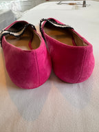 Pair of pink slippers on a light gray surface