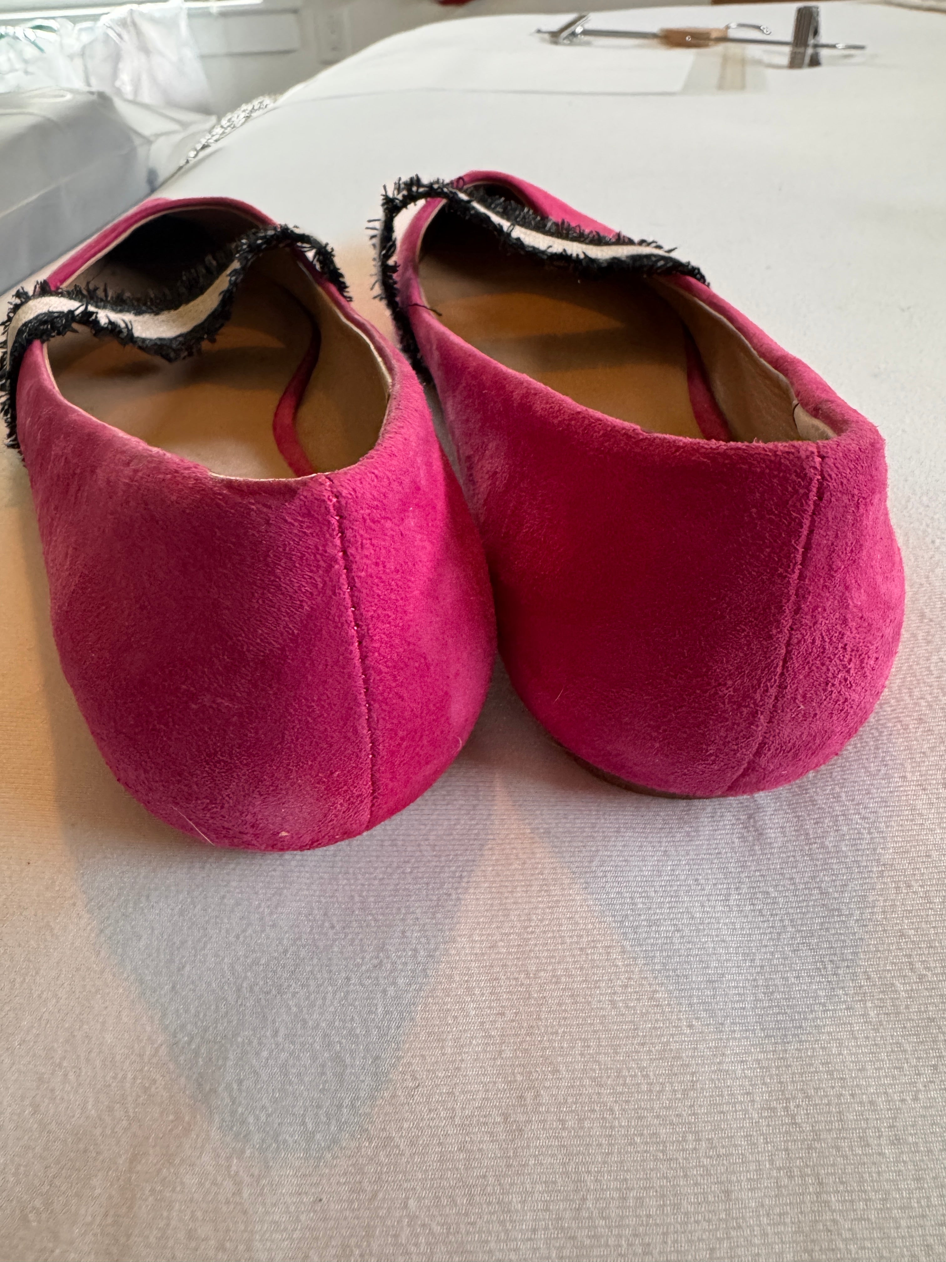 Pair of pink slippers on a light gray surface