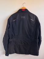 Black jacket on a mannequin against a white wall