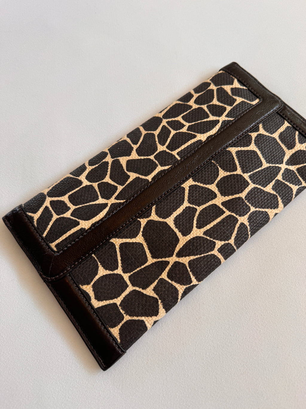 Backside of Banana Republic Clutch showcasing giraffe print canvas and leather
