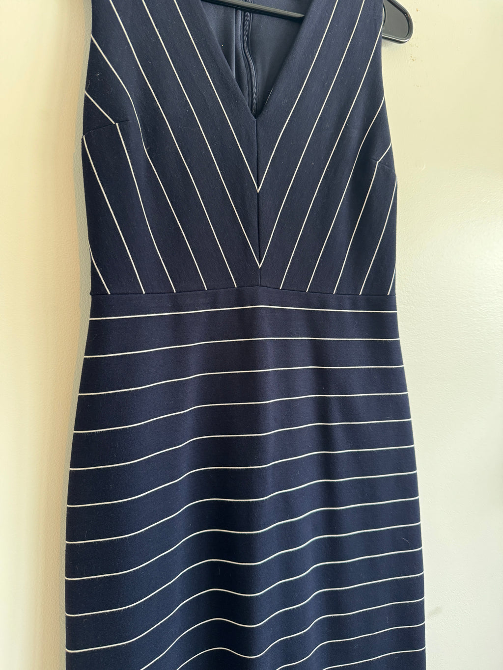 Navy pinstripe fabric on a beige surface