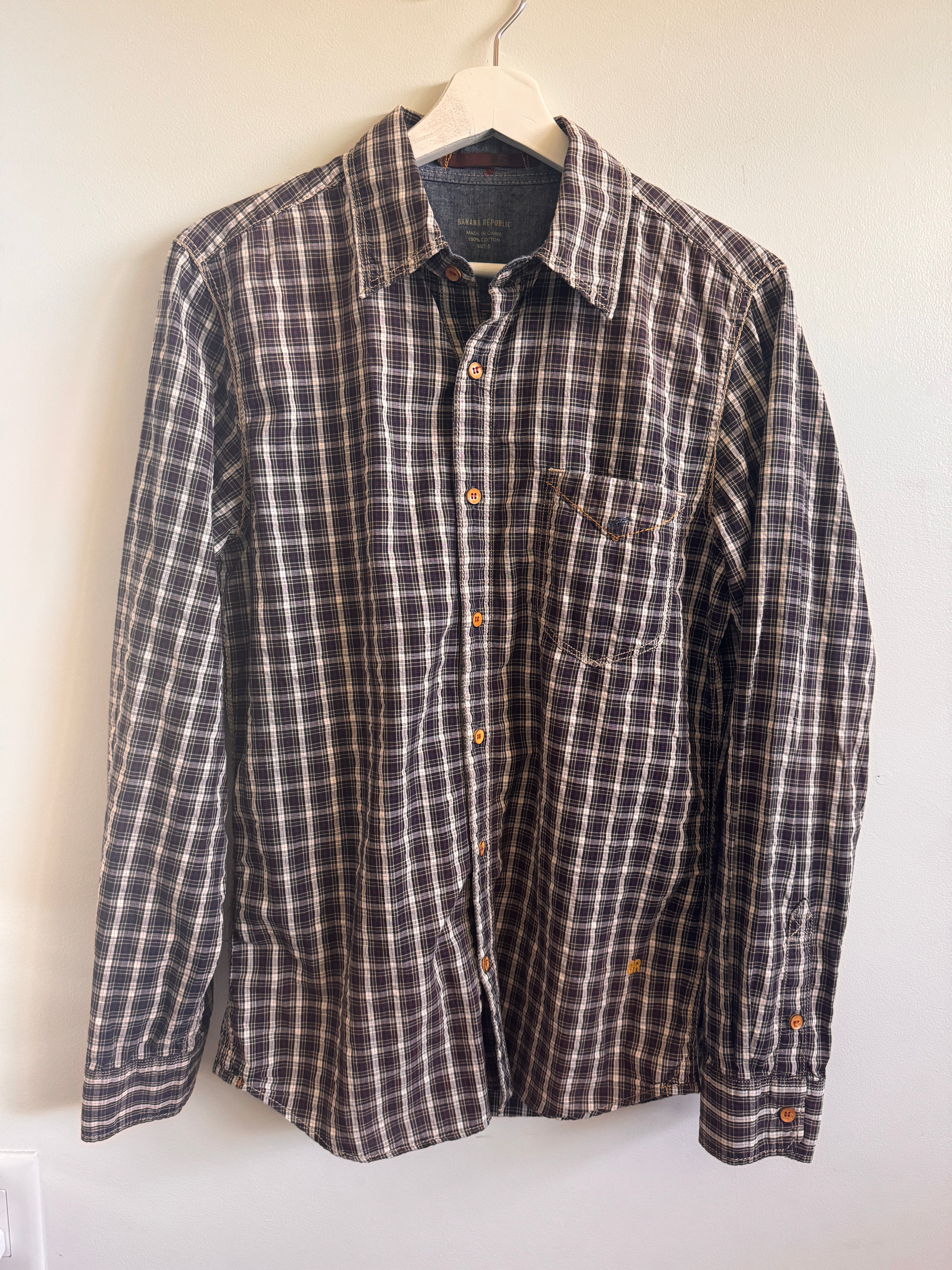 Plaid shirt on a hanger against a white wall