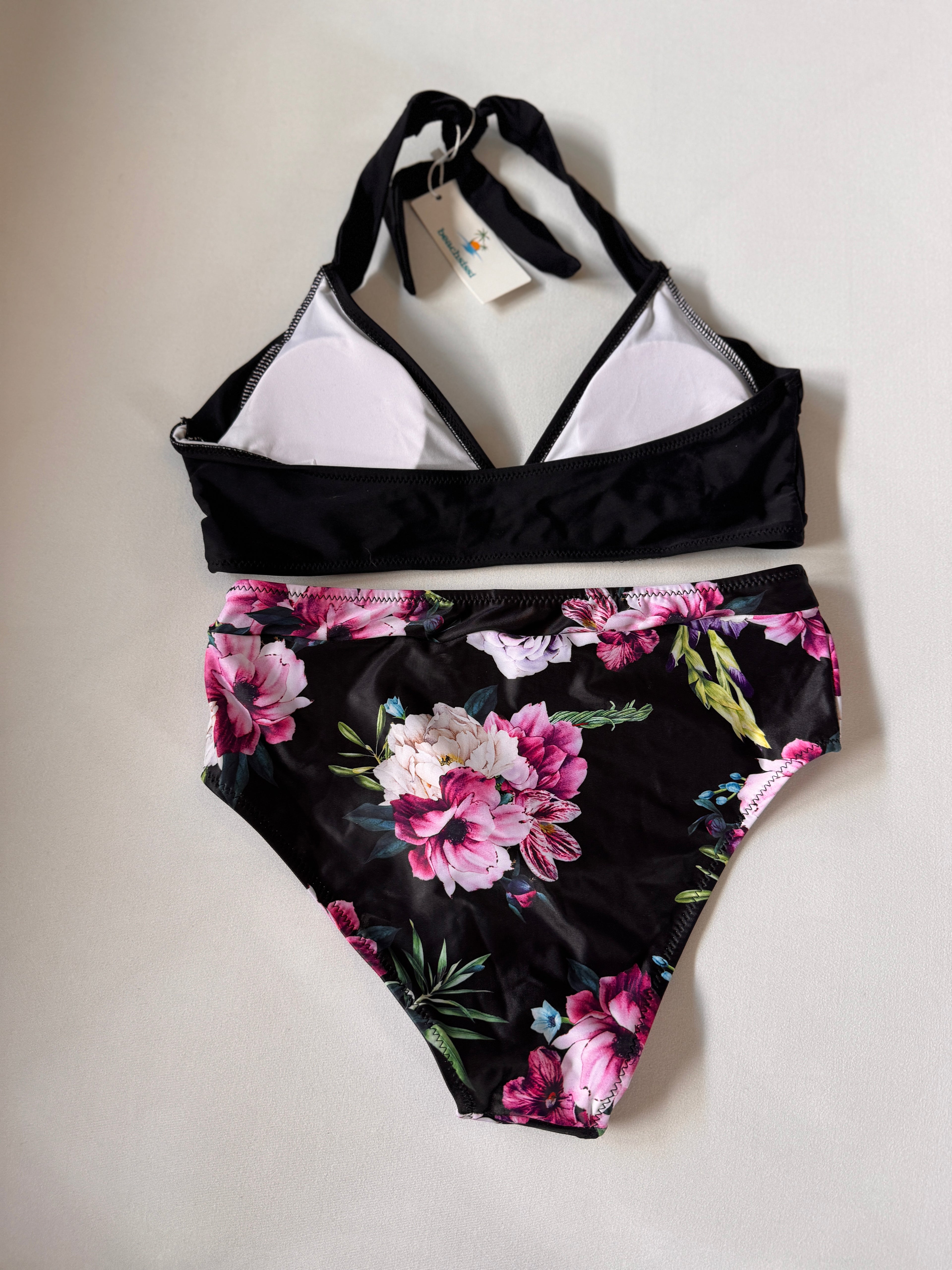 Black bikini set with floral design on a light gray background