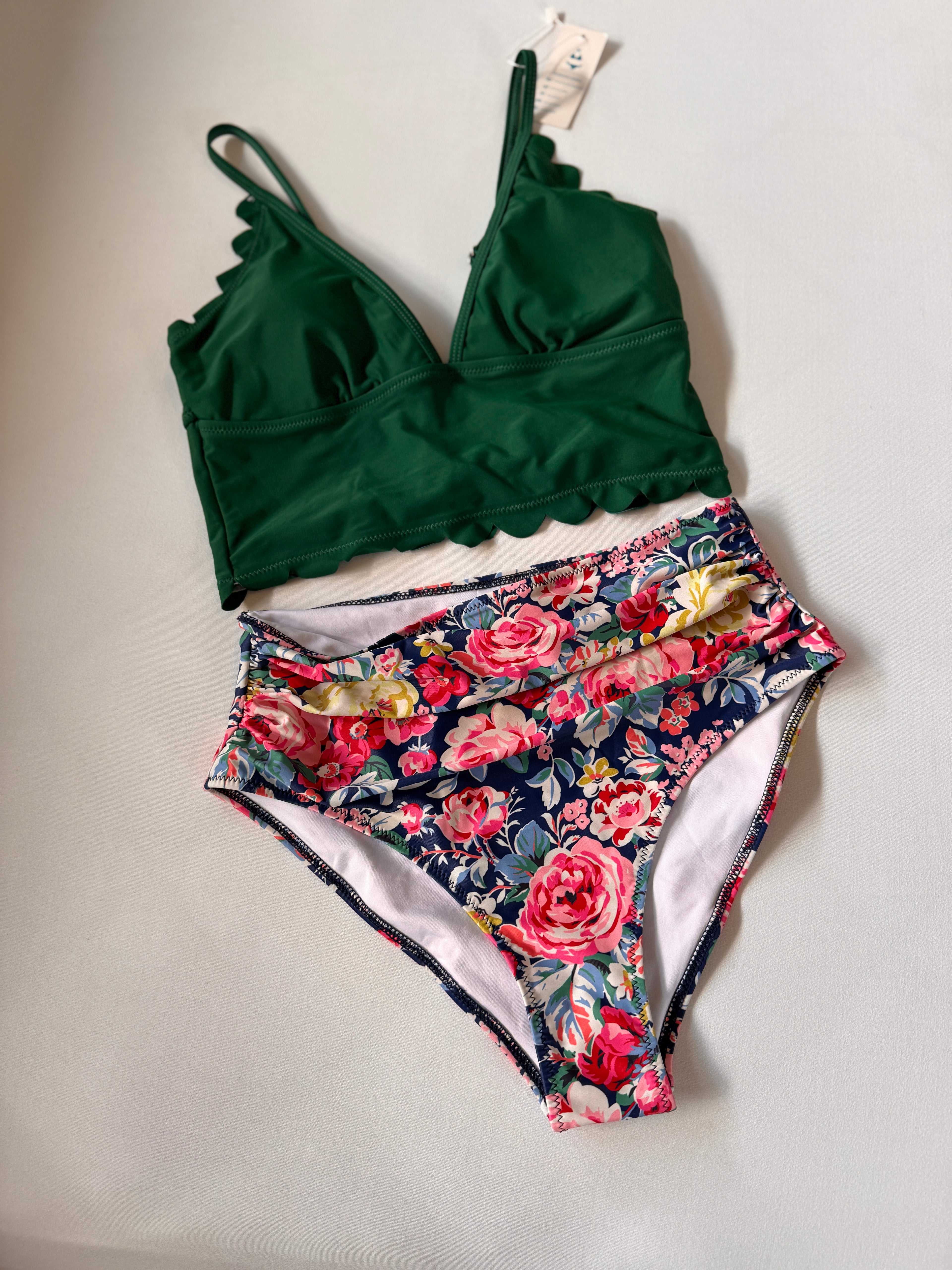 Green bikini top and floral patterned bottom on a light gray background