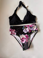 Black bikini set with floral design on a light gray background