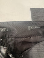 Close-up of a gray jacket with 'LOFT' and 'Marisa Skinny' labels on a beige background