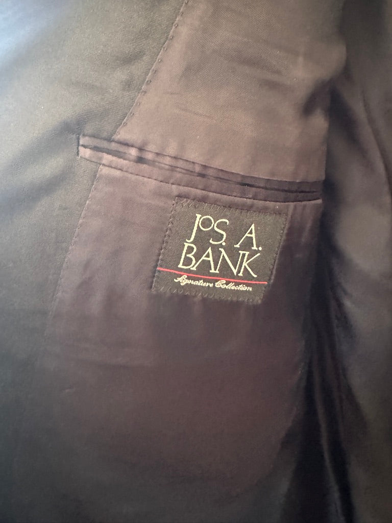 Close-up of anavy  jacket lining pocket with a sewn-on brand label reading 'Jos. A.
