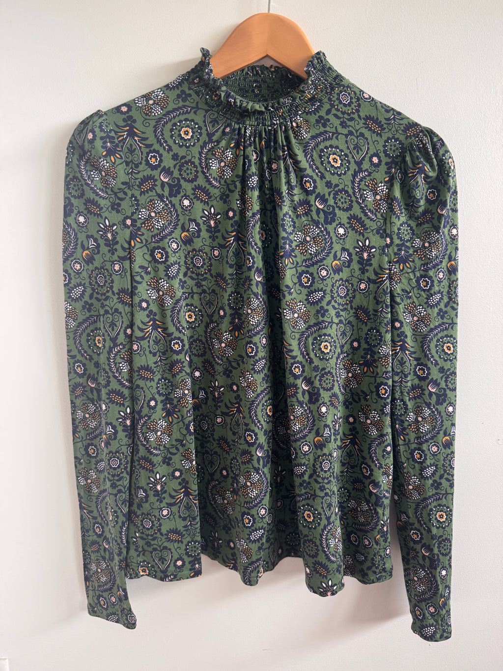 Folded green patterned fabric on a white background