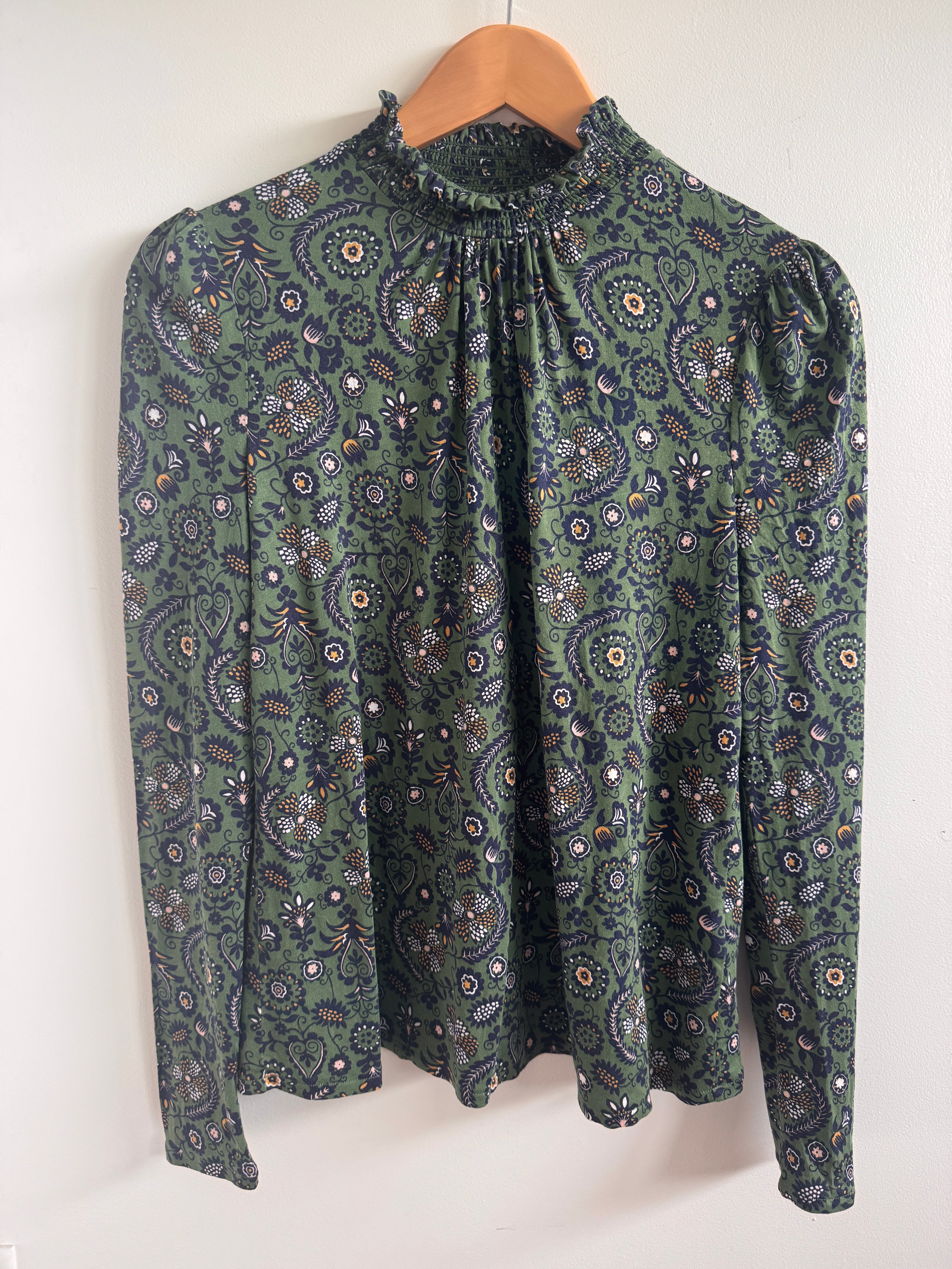 Folded green patterned fabric on a white background