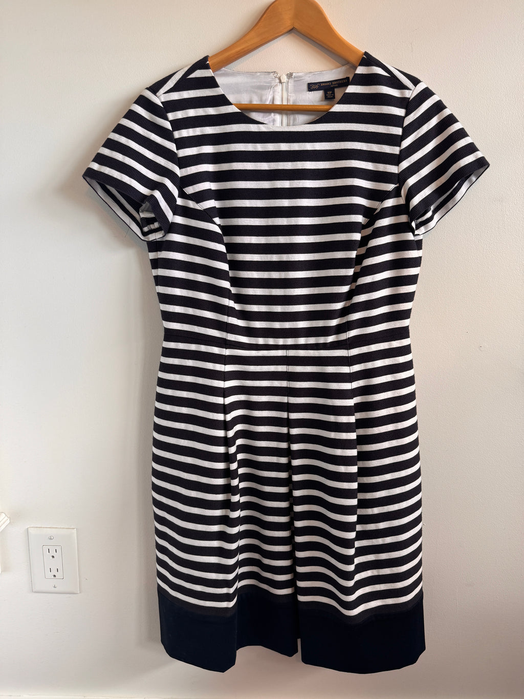 Navy and white striped dress with navy hemline on a white background