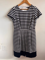 Navy and white striped dress with navy hemline on a white background
