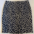 Black skirt with white polka dot pattern on a light gray background