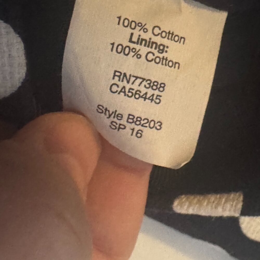 Close-up of a clothing label with text on a dark background