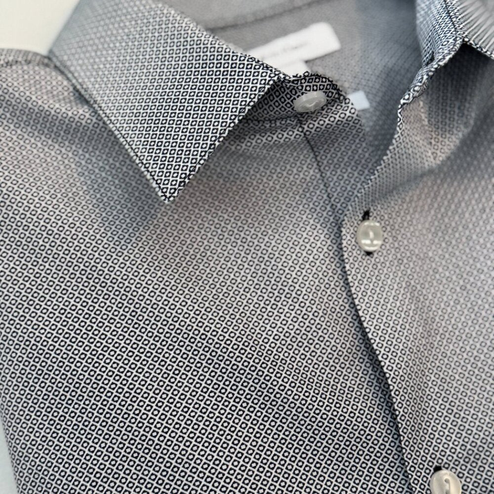 Close-up of a gray patterned shirt with collar and buttons.