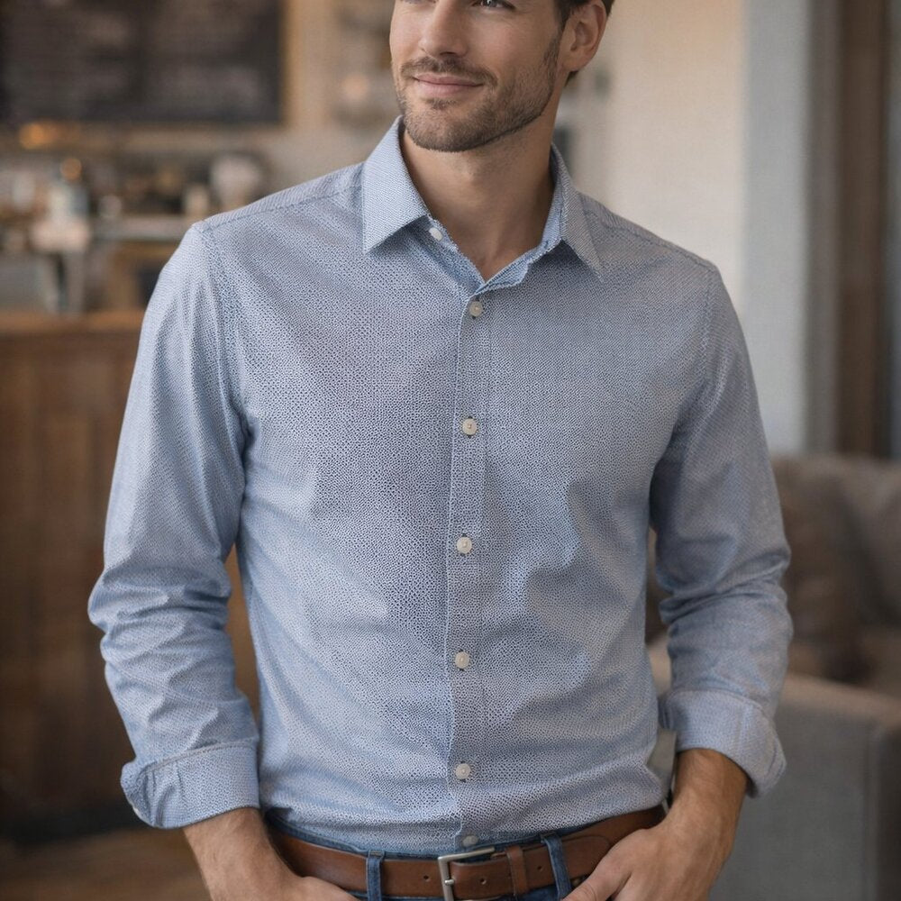 Man wearing a blue patterned shirt in a living room setting