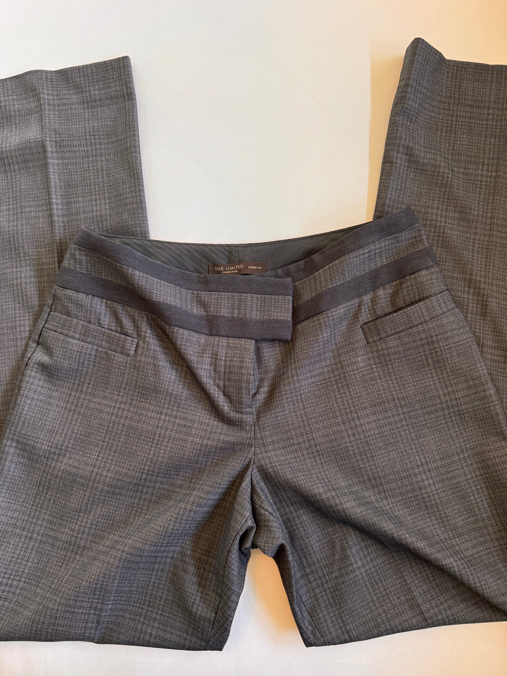 Grey and black plaid pants on a light colored background