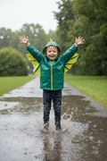 Lifestyle image of boy in dragon raincoat with wings attached to sleeves