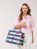 Woman holding a blue and white striped tote bag with cherry design on a light gray background