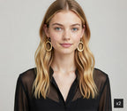 Woman wearing gold hoop earrings with a plain background