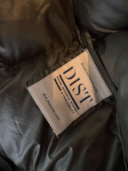 Label on a dark fabric surface with 'DIST' branding.