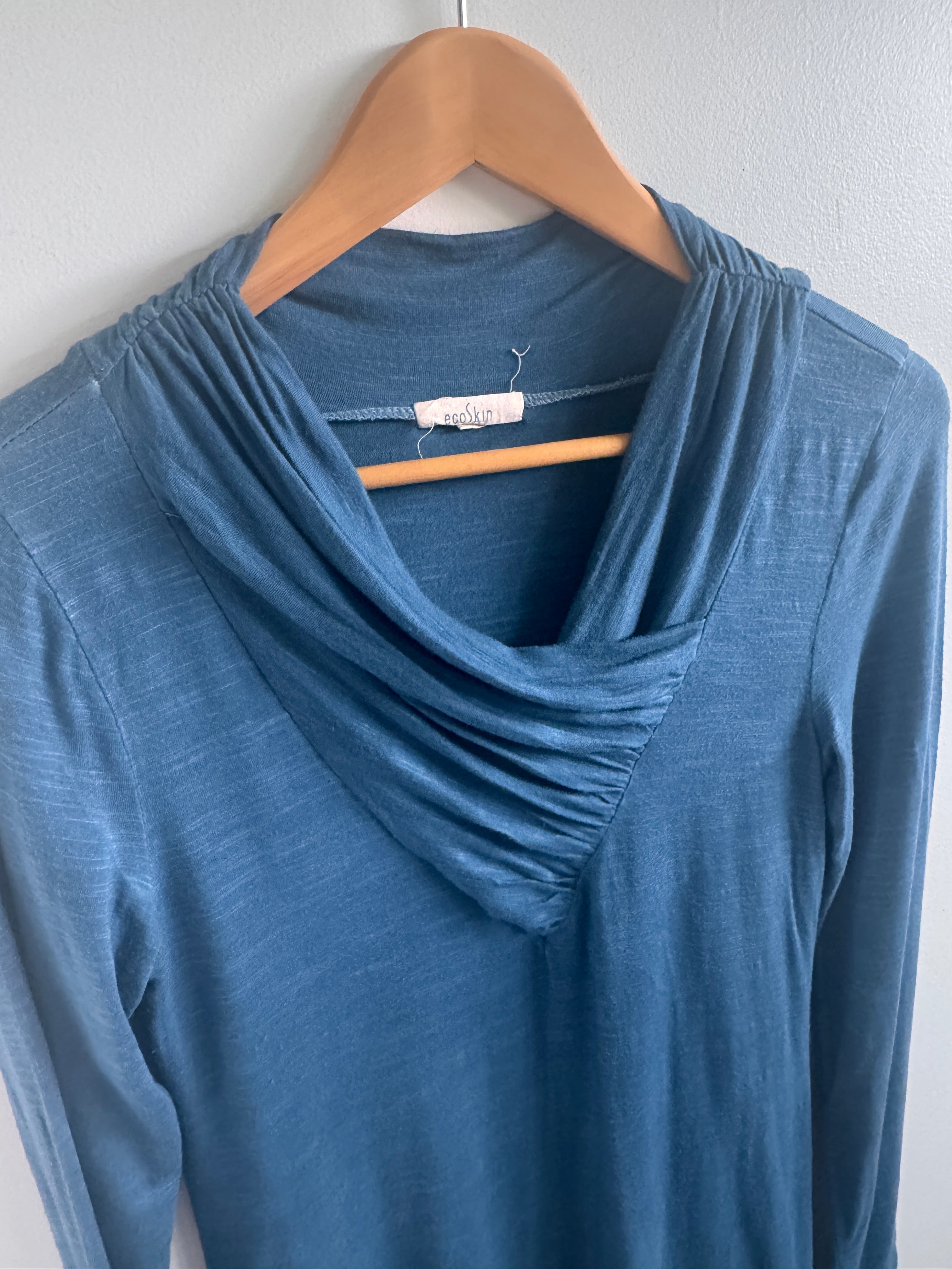 Blue dress on a hanger against a white background