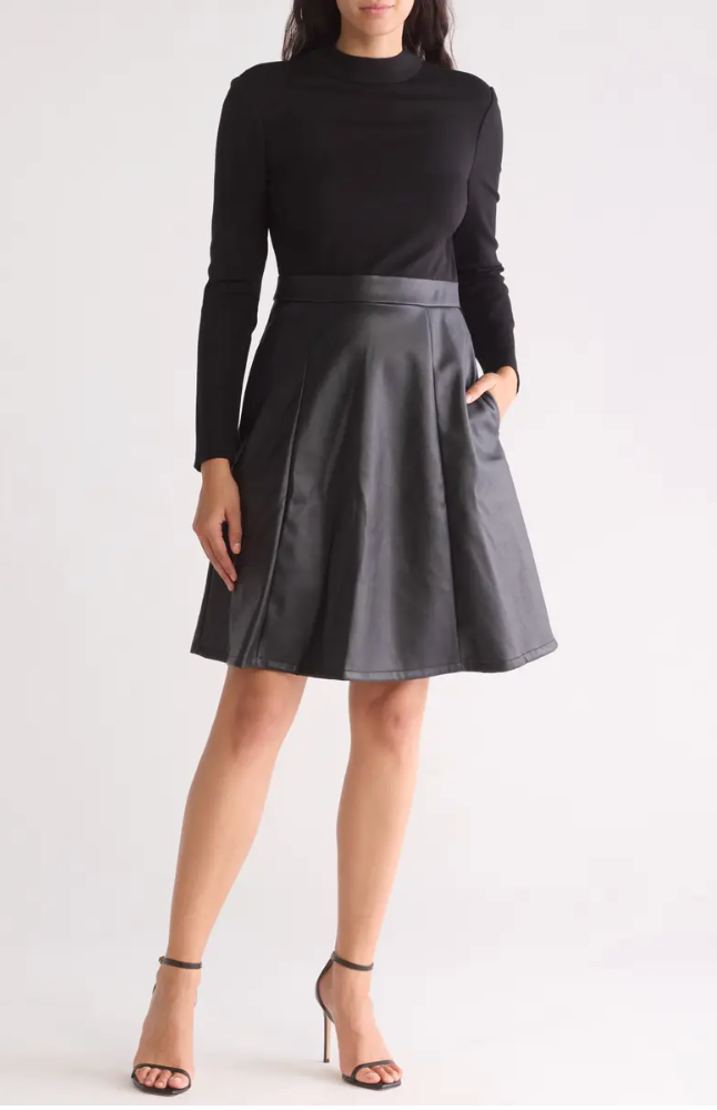 Person wearing a black turtleneck and gray skirt on a white background