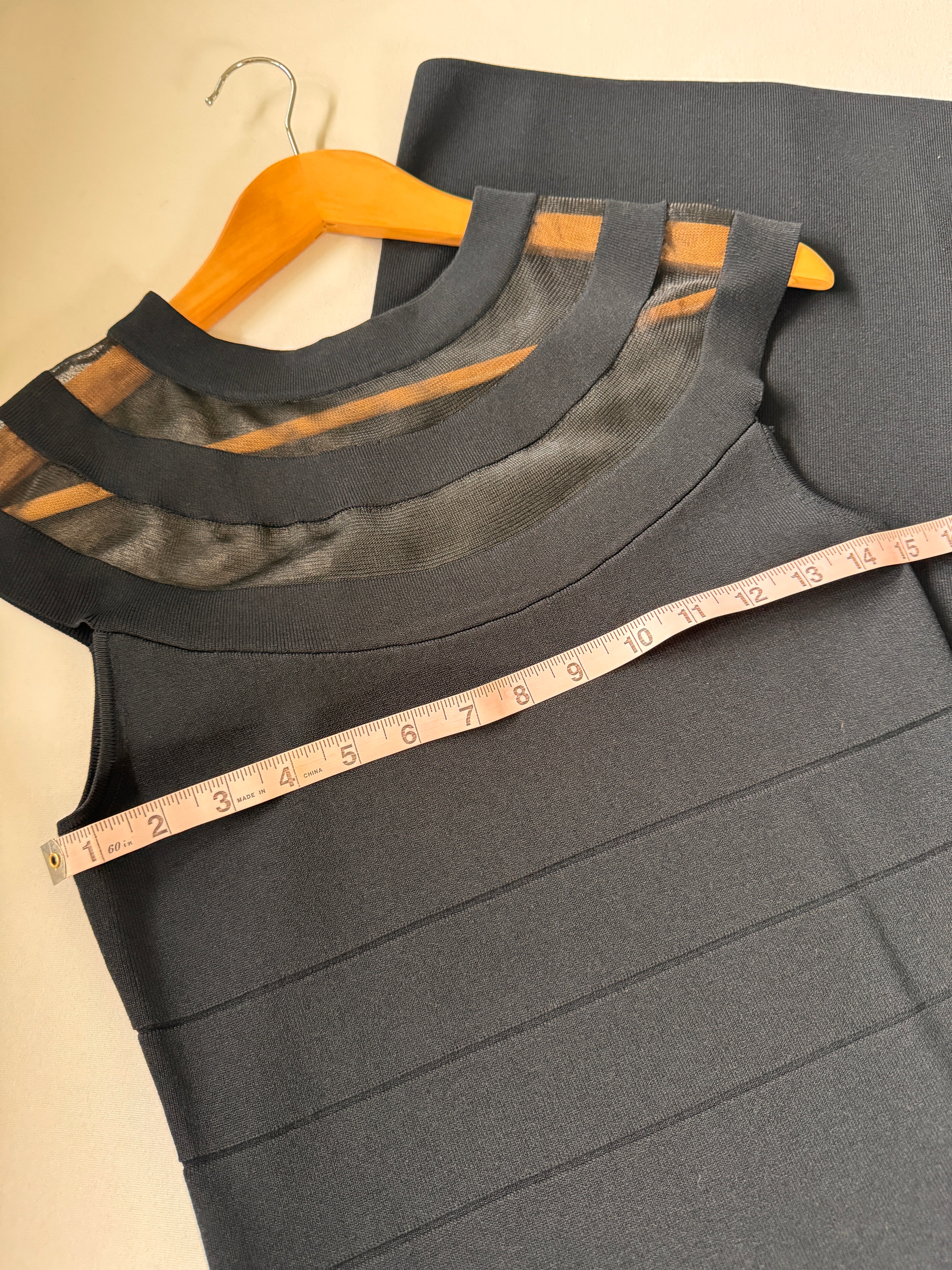 Black dress with a measuring tape on a beige background