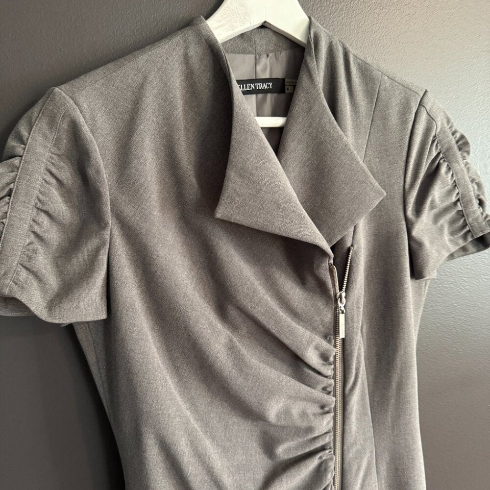 Gray short-sleeve dress with ruched details on a hanger against a neutral background