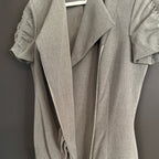 Gray dress with a zipper on a hanger against a dark background