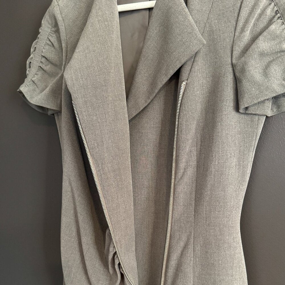 Gray dress with a zipper on a hanger against a dark background