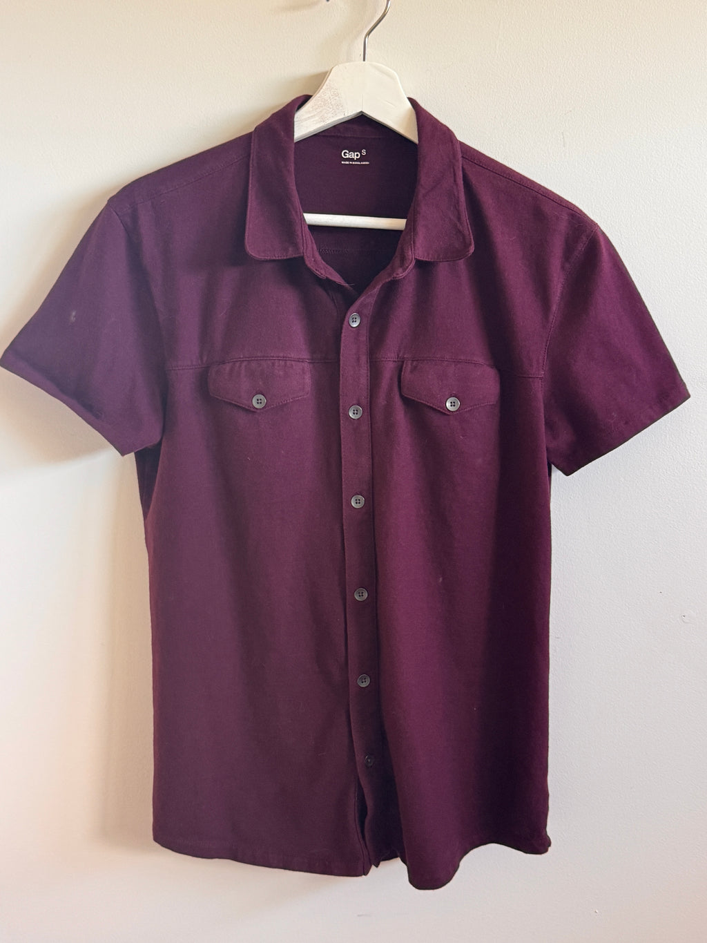 Hanging burgundy  shirt on a white background