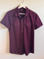 Hanging burgundy  shirt on a white background