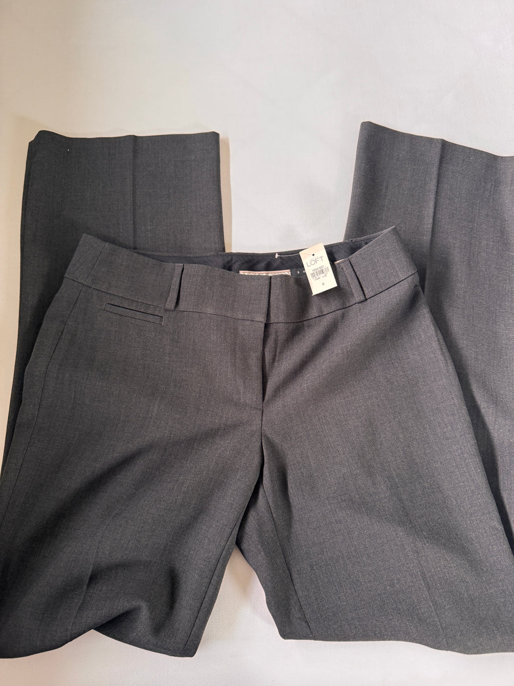 Gray pants with a tag on a light background