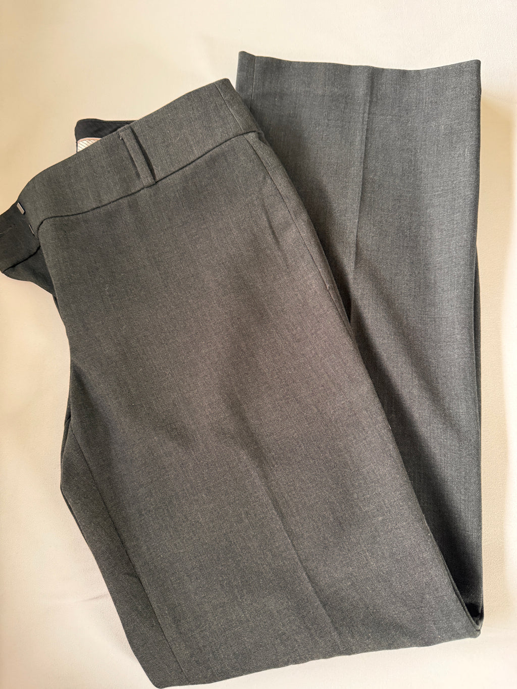 Gray pants folded on a beige surface